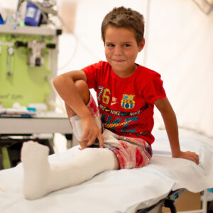 Gutt i sykeseng med gips på ben